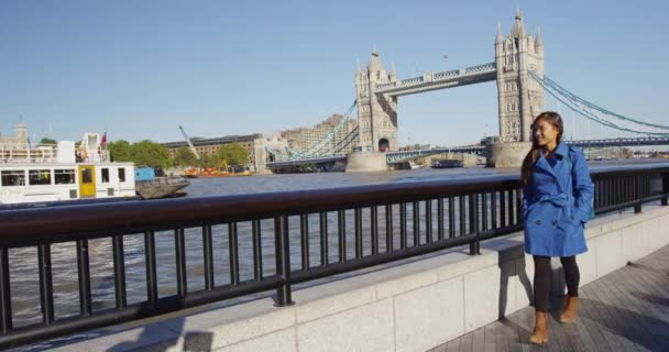 イギリスのテムズ川とロンドンタワーブリッジを歩くビジネスウーマン — ストック動画