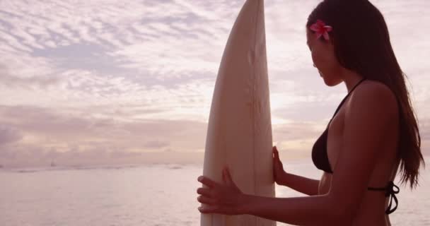 Surferin mit Surfbrett bei Sonnenuntergang am tropischen Strand — Stockvideo