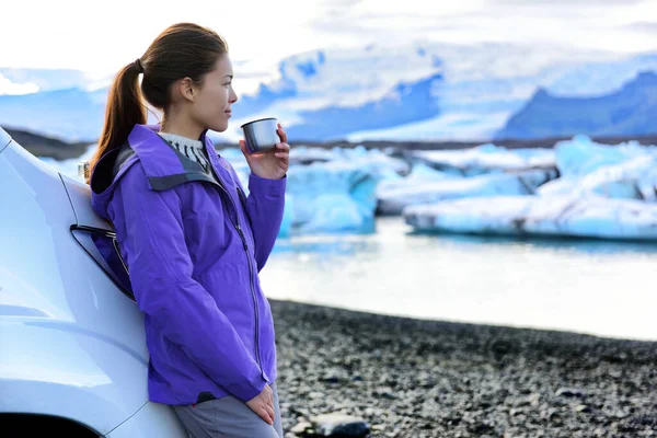 Viagem de autocaravana. Mulher bebendo café da manhã na frente de motorhome enquanto dirigindo van de acampamento na Islândia viagem de carro. Motorista turístico asiático fazendo uma pausa em férias de aventura Jokulsarlon, Islândia — Fotografia de Stock