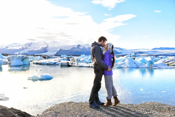 Couple kissing embracing in love on Iceland. People enjoying Jokulsarlon glacial lagoon. Romantic couple visiting destination landmark and tourist attraction, Vatnajokull glacier lake landscape — Stock fotografie