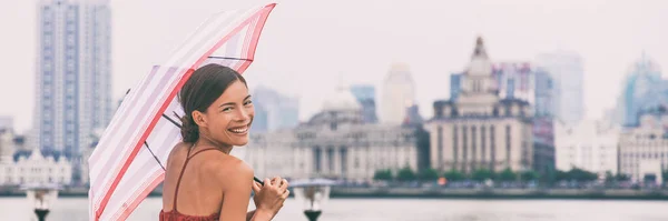 Chinese umbrella woman in rain background banner. Urban landscape panorama of Shanghai city Bund, Pudong Huangpu district, rainy summer day. Tourist traveling in Shanghai, China, Asia travel — Stock Fotó