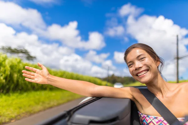 汽车公路旅行妇女的自由与手在风中飘浮。亚洲女孩坐在敞篷可兑换汽车无忧无虑地享受公路旅行假期，胳膊伸出窗外的概念 — 图库照片