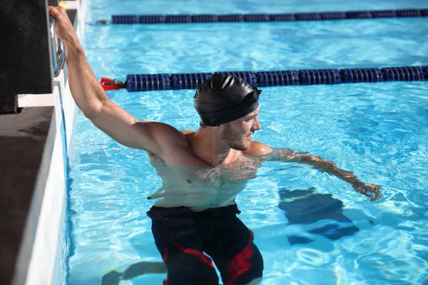 水泳プールでの競争レースの開始時に水泳スポーツ選手の男-泳ぐ準備ができている。訓練における動機と集中 — ストック写真