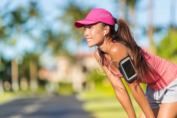 Happy summer running woman runner listening to music on phone sports armband with touchscreen and headphones earphones on city street, active lifestyle. Fitness Asian girl ready for jogging — Stockfoto