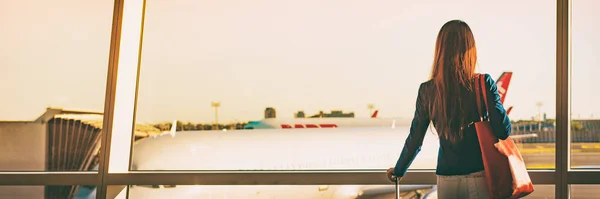 Airport panoramic banner holiday travel tourist business woman waiting in lounge terminal for flight. Silhouette looking at window delayed boarding time panorama — Stockfoto