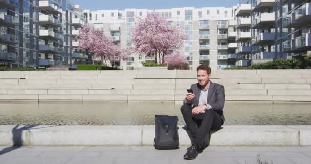 Smartphone - Fiatal városi profi üzletember telefonos pihenés a városban — Stock videók