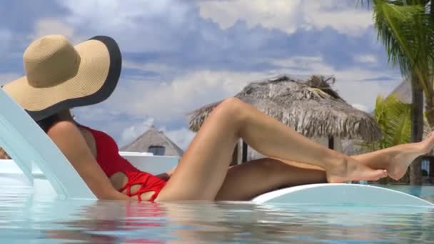 Бассейн роскошного отеля женщина, отдыхающая в кресле-лофте на летних каникулах — стоковое видео