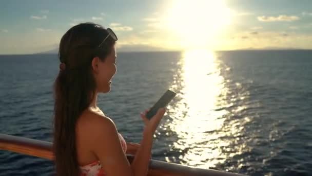 Женщина разговаривает по телефону на круизных лайнерах наслаждаясь закатом в море — стоковое видео