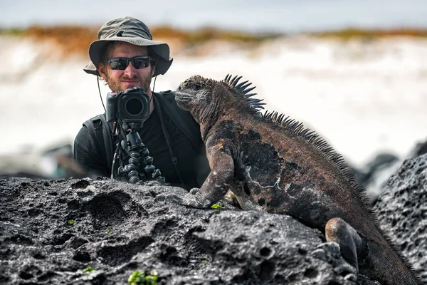 Galápagos Iguana y la naturaleza turística fotógrafo de vida silvestre tomando fotos — Foto de Stock