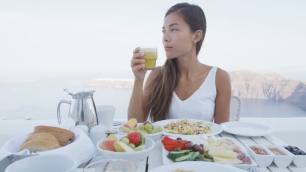 Asiatin isst Frühstück und trinkt Saft — Stockvideo