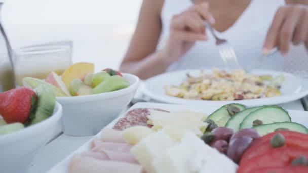 Vrouw eet gezond ontbijt op terras buiten — Stockvideo