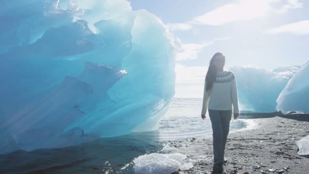 アイスランドJokulsarlon Icebergビーチ-氷のビーチで氷山を見る女性 — ストック動画