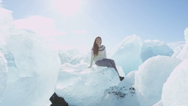 Iceland tourist at Jokulsarlon Iceberg beach sitting on icebergs on Ice beach — стоковое видео