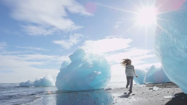 Izland természet Jokulsarlon Iceberg strand - nő boldog futás szórakozás — Stock videók