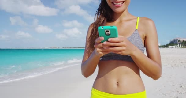 Woman with smartphone standing on beautiful exotic beach — Stock Video