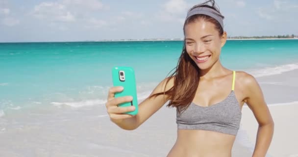 Beautiful young woman taking selfie on beach — Stock Video