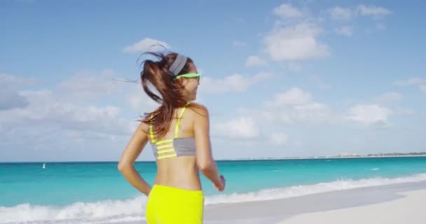 Feliz mujer deportiva corriendo divirtiéndose alegre en vacaciones de playa — Vídeo de stock