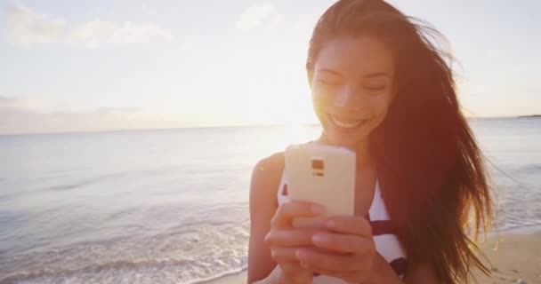 Τηλέφωνο - γυναίκα sms γραπτών μηνυμάτων chat χρησιμοποιώντας το τηλέφωνο app χαμογελώντας χαρούμενος έξω — Αρχείο Βίντεο