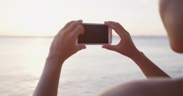 Telefon - Žena fotografování pomocí smartphone pláž západ slunce — Stock video