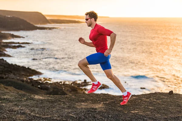 Trail corridore sport fitness uomo ultra running sulla scogliera dell'oceano al tramonto. Atleta sportivo che fa jogging allenandosi all'aperto in un paesaggio roccioso in riva al mare. Stile di vita attivo vestiti compressione. — Foto Stock