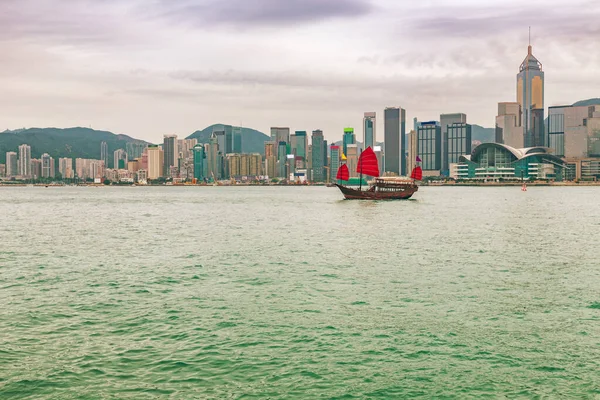 Hong Kong vue de la ville de Kowloon au coucher du soleil avec voilier rouge hors-bord dans la rivière. Asie voyage horizon arrière-plan paysage. — Photo