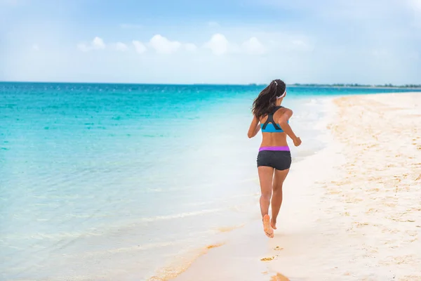 Fitness sports athlete woman runner jogging on Caribbean beach vacation destination. Running girl living an active and fit lifestyle on holiday. Cellulite weight loss concept. — 图库照片