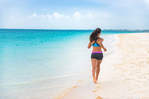 Fitness-Sportlerin joggt auf Karibik-Strandurlaub. Laufmädchen, die im Urlaub einen aktiven und fitten Lebensstil leben. Konzept zur Gewichtsabnahme bei Cellulite. — Stockfoto