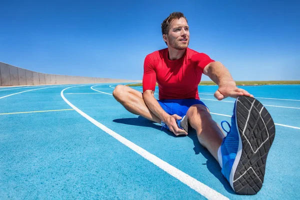 Man runner stretching legs preparing for run training on outdoor stadium running tracks Male fitness sport athlete outdoors doing warm-up toe touch single leg exercise. — Stock Photo, Image