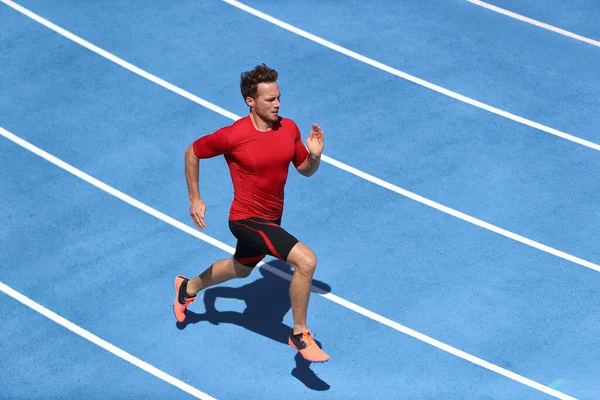 Sprinter άνθρωπος τρέχει σε μπλε λωρίδες κομμάτια στην πίστα και γήπεδο σε υψηλή ταχύτητα κορυφαία θέα. Άντρας αθλητής δρομέας σε έντονη προπόνηση σπριντ. Εκτέλεση αθλητικής ιδέας — Φωτογραφία Αρχείου