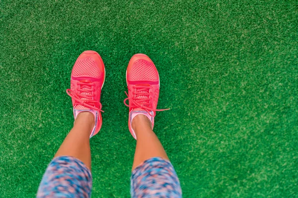 Fitness en gezondheid concept. Bovenaanzicht van hardloopschoenen vrouw staan op gras pov selfie van voeten tijdens de oefening run workout buiten. Sport en actieve levensstijl. — Stockfoto