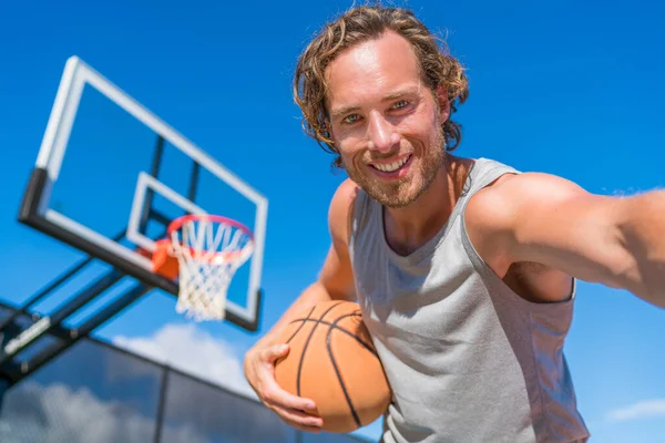 Basketbalspeler man neemt leuke selfie foto op het net met basketbal. — Stockfoto