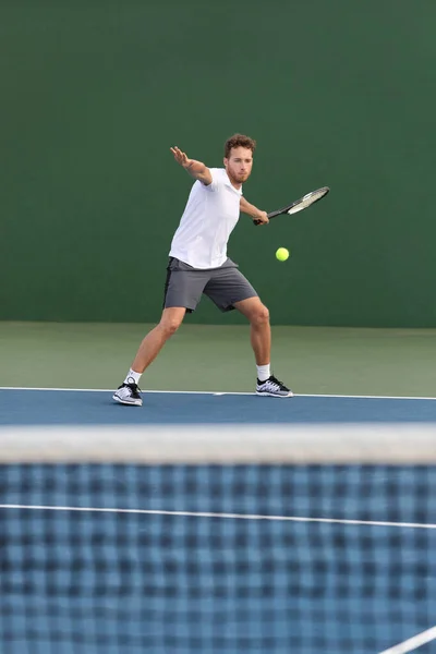 Profesionální tenista sportovec muž bít předem míč přes síť na tvrdém hřišti hrát tenisový zápas. Sportovní hra fitness životní styl — Stock fotografie