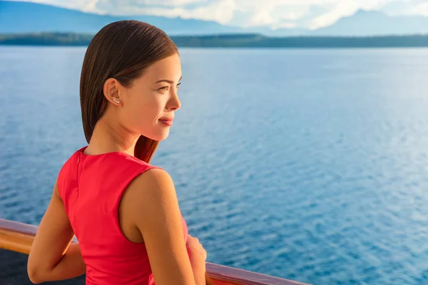 Woman enjoying view of ocean horizon from luxury cruise balcony. Serene ship passenger relaxing outside on suite deck. European travel summer vacation destination. — Photo