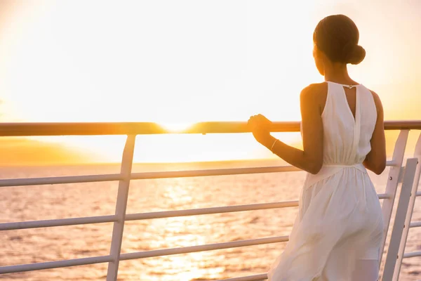 Cruise ship vacation woman enjoying sunset on travel at sea. Elegant happy woman in white dress looking at ocean relaxing on luxury cruise liner boat. — Stok fotoğraf