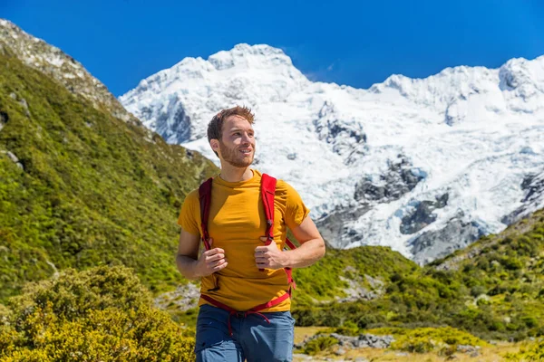 マウントクックトレイルのニュージーランドの山々を雪でハイキングする男は山の峰をかぶった。自然景観の中を歩く幸せなハイカー — ストック写真