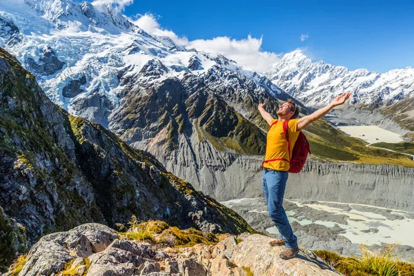 New Zealand success hiker man hiking at Mount Cook. Cheering adventure tourist reaching goal challenge on top of mountain summit trail —  Fotos de Stock