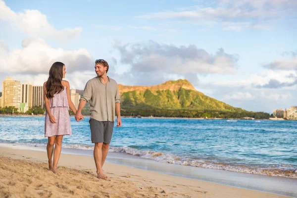 Paar wandelingen op Waikiki strand Hawaï vakantie. Gelukkig paar in liefde ontspannen bij zonsondergang op toeristische beroemde reisbestemming in Honolulu, Oahu, Hawaii — Stockfoto