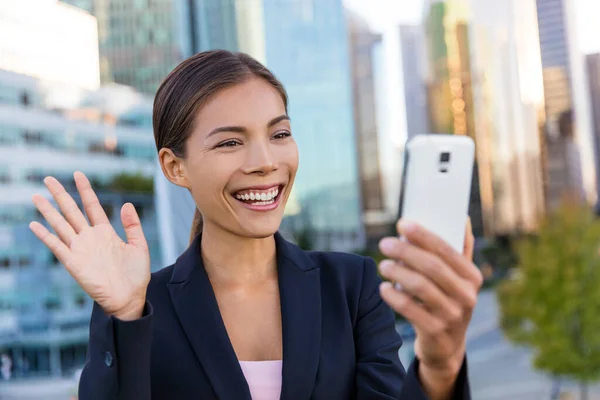 Концепция деловой встречи в видеочате. Деловая женщина делает селфи-фото, используя приложение для смартфона на смартфоне для социальных сетей, улыбаясь счастливой в пиджаке на открытом воздухе. женщина-профессионал — стоковое фото