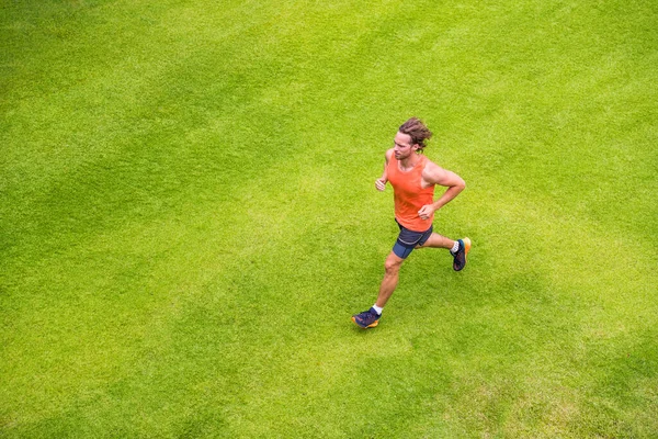 Jogging man training cardio morning run routine on grass park summer. Running runner active lifestyle - View from above — Stock Photo, Image