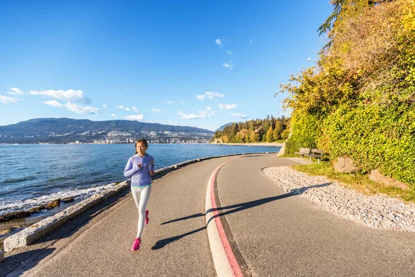 Běžkyně ve Stanley Parku ve Vancouveru, Britská Kolumbie. Žena jogging ve městě venku těší zdravý aktivní životní styl — Stock fotografie