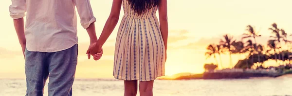 Paar kijkende naar zonsondergang op Hawaïaans strand samen, ontspannend hand in hand panorama banner. Man, vrouw in de liefde concept — Stockfoto