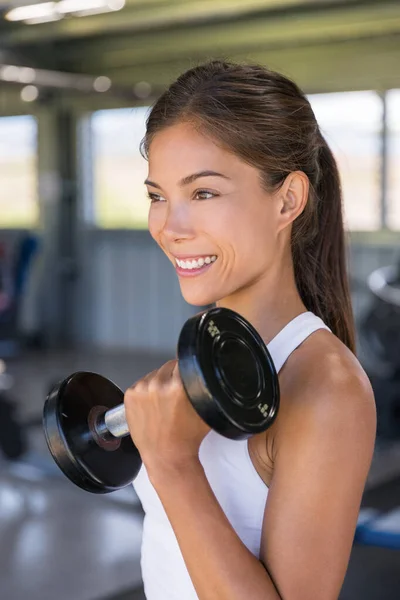 Asian woman strength training biceps with free weights at gym, lifting dumbbells for arm workout — Foto Stock