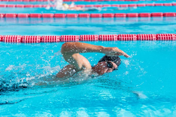 Swimmer man fitness training at swimming pool. Professional male athlete doing crawl freestyle stroke technique — Foto de Stock