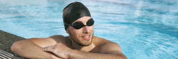 游泳运动员男子身穿运动护目镜，头戴游泳帽，身穿室内游泳池肖像全景横幅。活泼活泼的人的生活方式的画像 — 图库照片