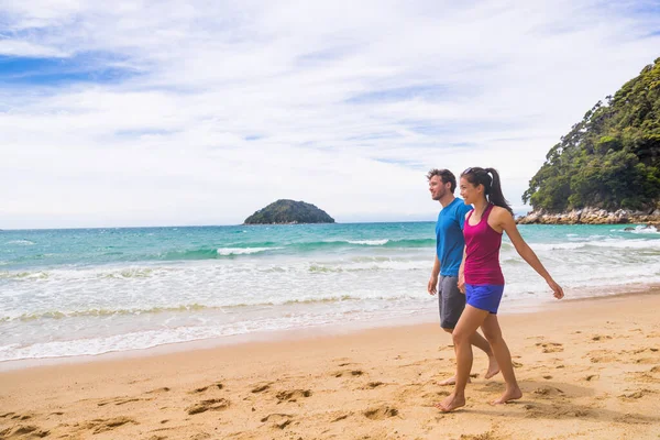 Új-Zéland strand pár túrázók séta a tengerparti pályán Abel Tasman Nemzeti Park. Emberek tramping pihenés a természetben a szabadban. — Stock Fotó