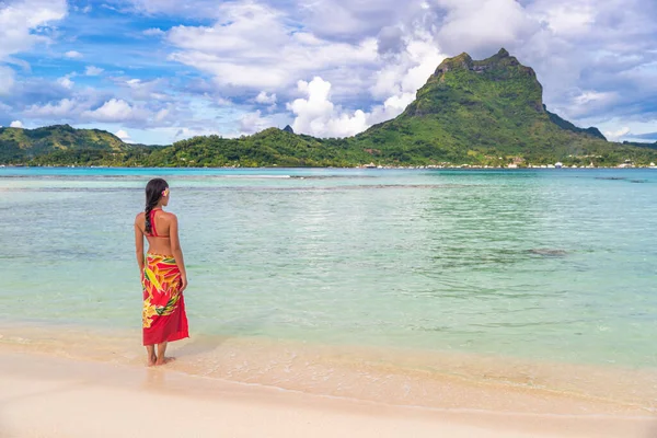 法属波利尼西亚热带海滩度假回来.波拉博拉岛著名的目的地妇女塔希提穿着波利尼西亚裙沐浴在青绿色的海洋。天堂假日 — 图库照片