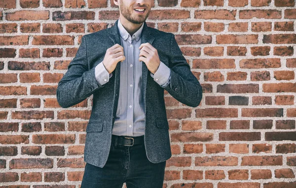 Suit man smart casual outfit young businessman adjusting collar of his blue wool blazer with shirt against brick wall background at office. Urban lifestyle — Stock Photo, Image