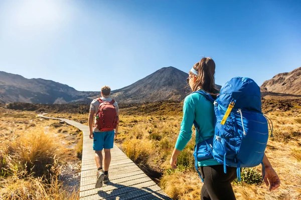 Nya Zeeland Vandringspar Backpackers Tramping vid Tongariro nationalpark. Manliga och kvinnliga vandrare vandrar vid berget Ngauruhoe. Människor som lever hälsosam aktiv livsstil utomhus — Stockfoto