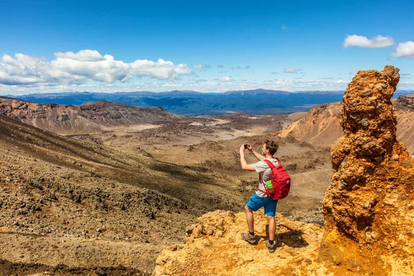 Yeni Zelanda Tongariro Alp Dağları 'nda doğa yürüyüşçüsü arka planda fotoğraf çekiyor. Volkanik dağlarda fotoğraf çeken mutlu serseri. Yaz macerası Seyahat — Stok fotoğraf