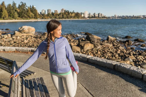 カナダのバンクーバー、スタンレーパークで実行する前にストレッチアクティブなライフスタイルアジアの女性。健康的な都市ライフスタイルの人々のジョギングフィットネス — ストック写真